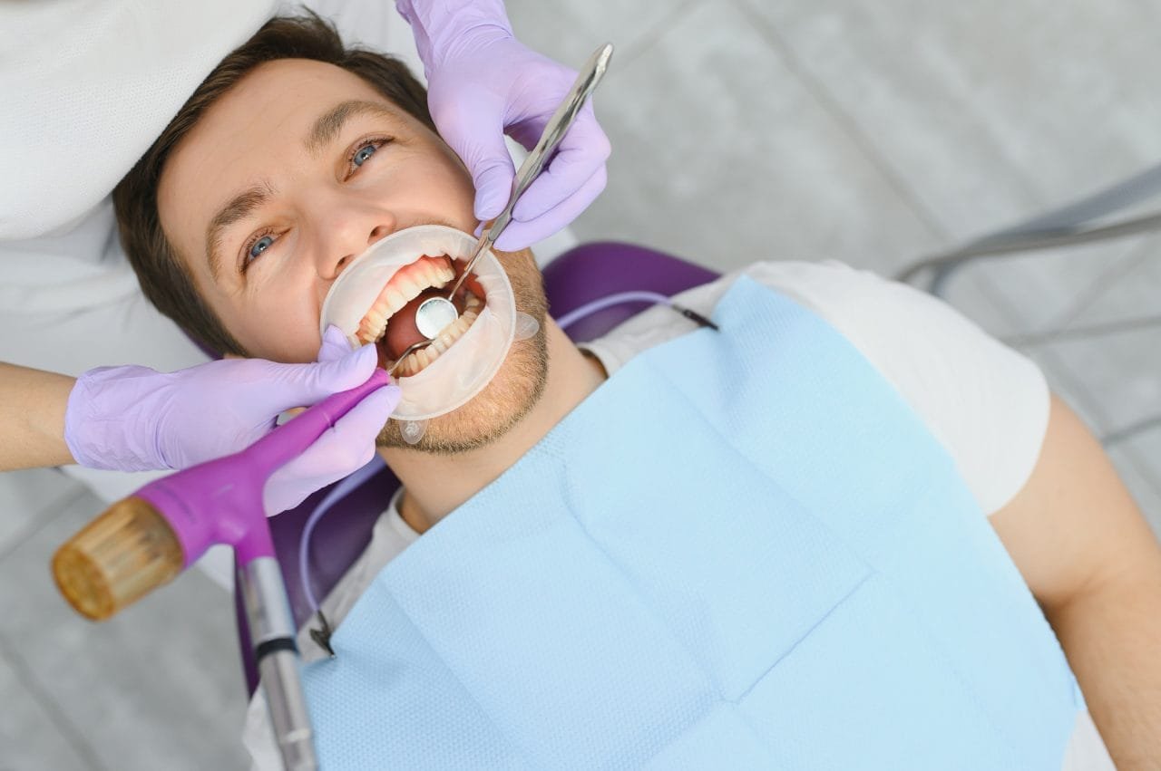 periodontal-services-closeup-shot-of-smiling-man-getting-treatment-in-stomatologic-clinic Dulicate Title